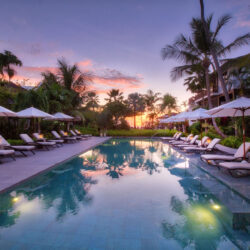 The Sandpiper St. James Barbados – Tranquil lap pool at sunset with palm trees, luxury loungers, and tropical gardens.